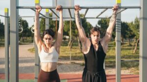 Pratiquant en dead hang, suspendu bras tendus à une barre de traction