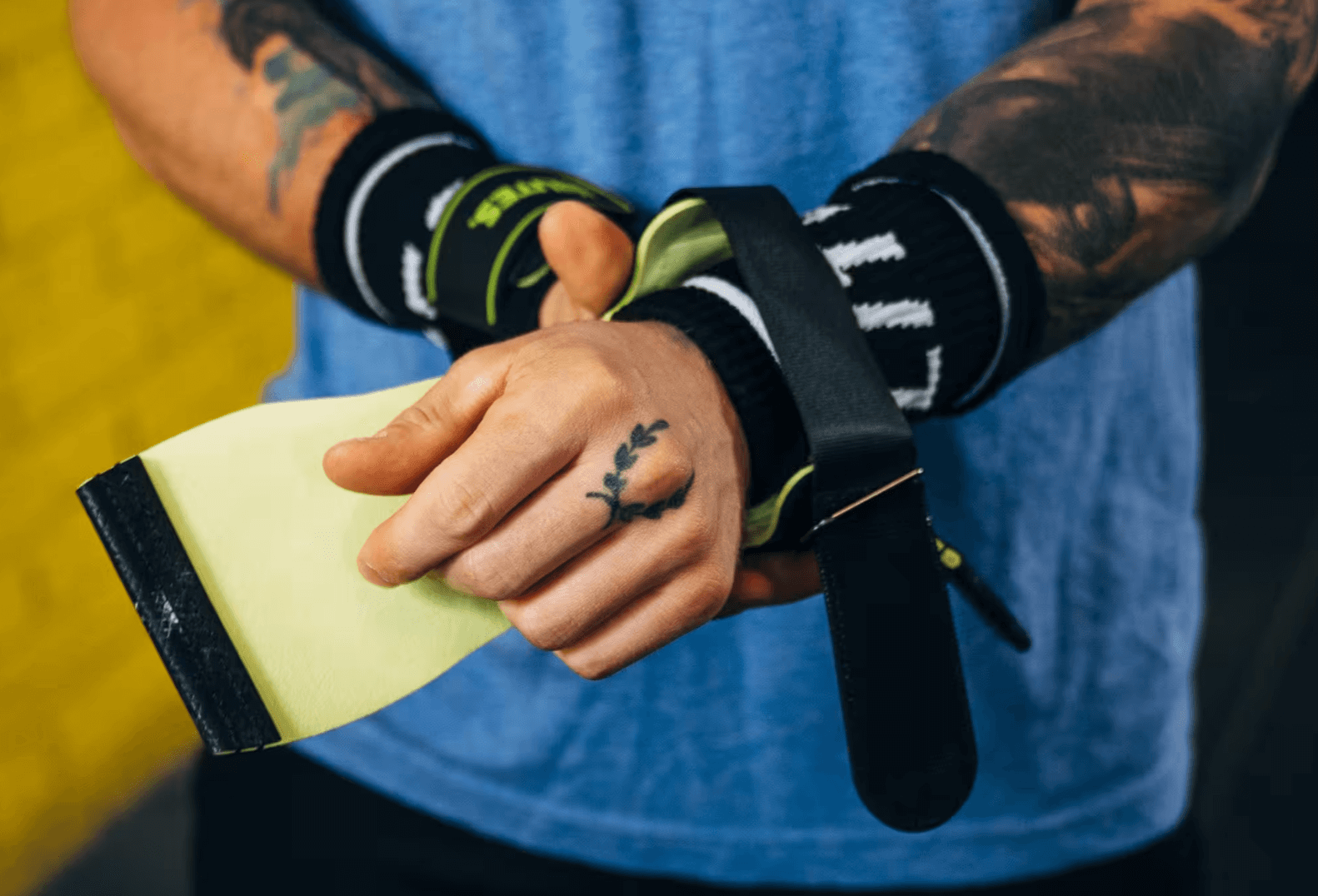 Manique CrossFit en cuir maintenue dans la paume avant un exercice à la barre